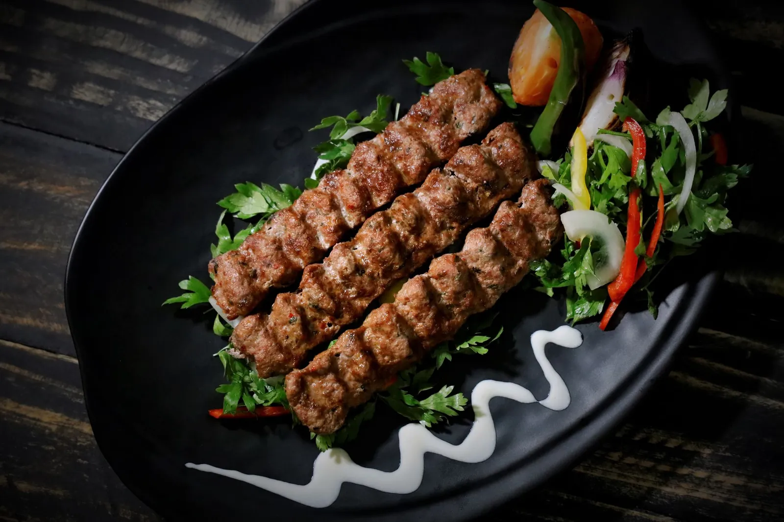 Adana kebap sur assiette noire